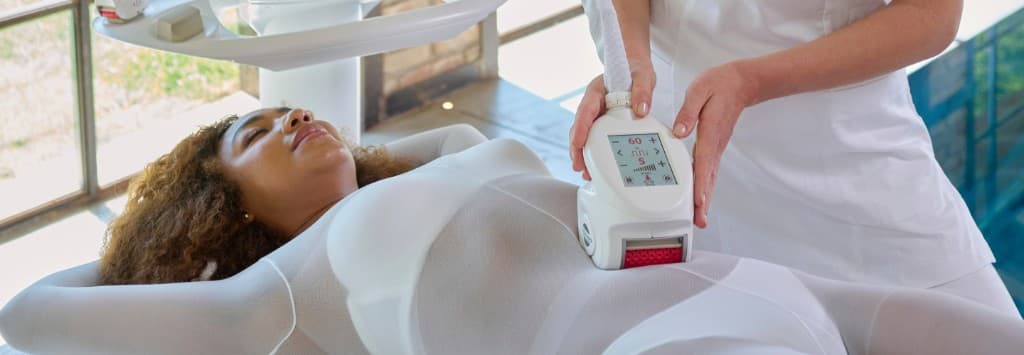 Terapeută aplicând tratamentul iCOONE Roboderm pe abdomen